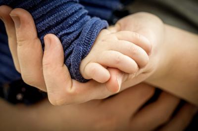 adult holding child's hand